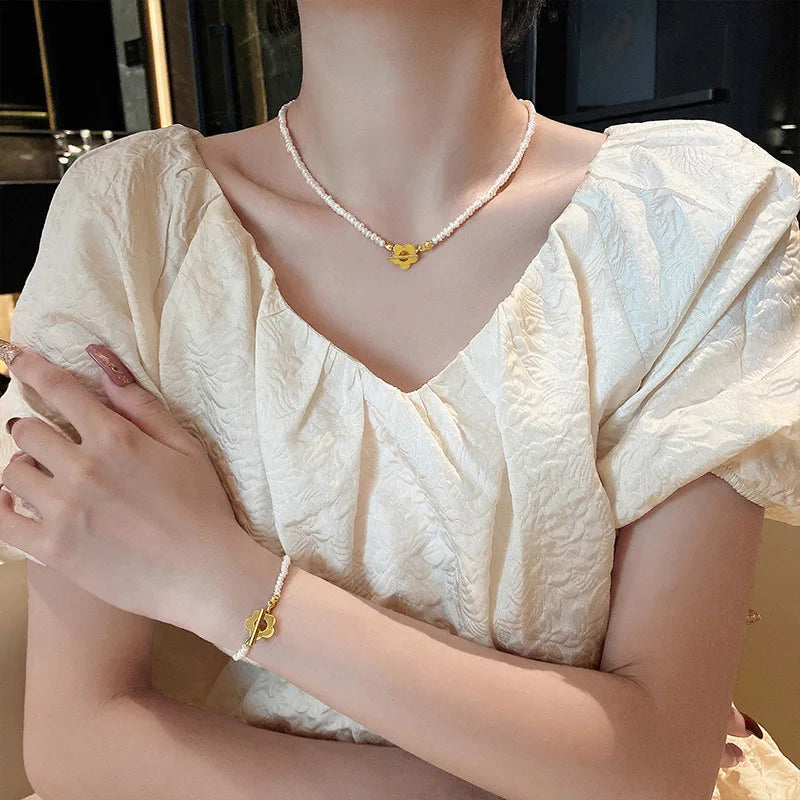 Elegante Perlenhalskette, Perlenarmkette mit goldfarbenem Blumenverschluss