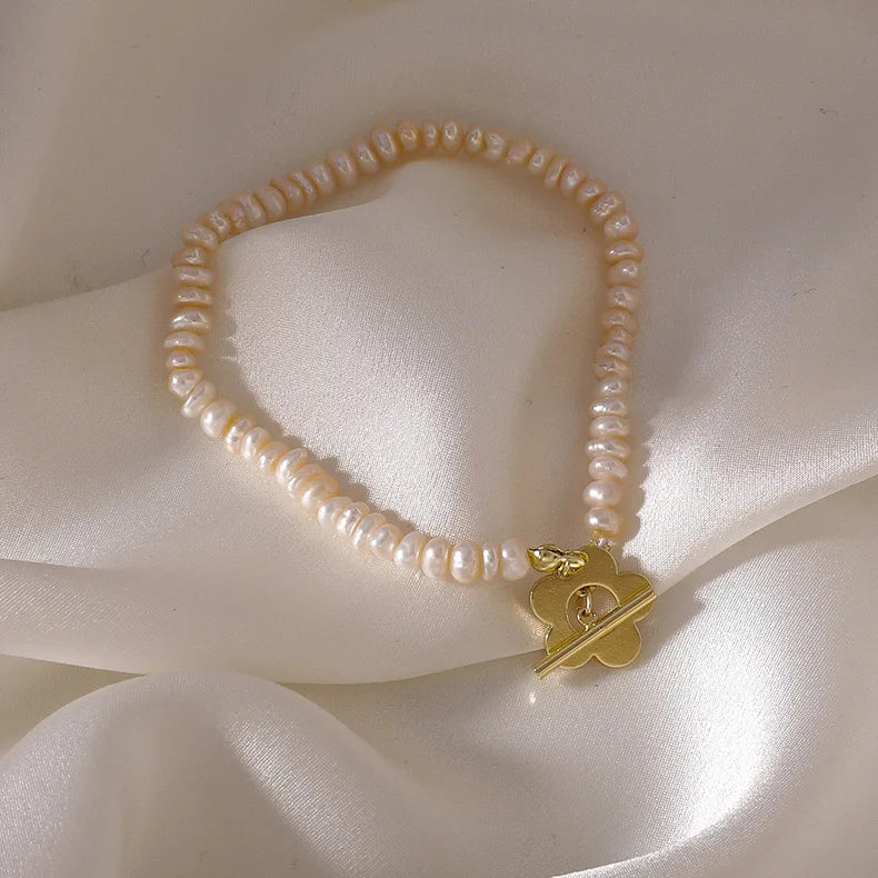 Elegante Perlenhalskette, Perlenarmkette mit goldfarbenem Blumenverschluss